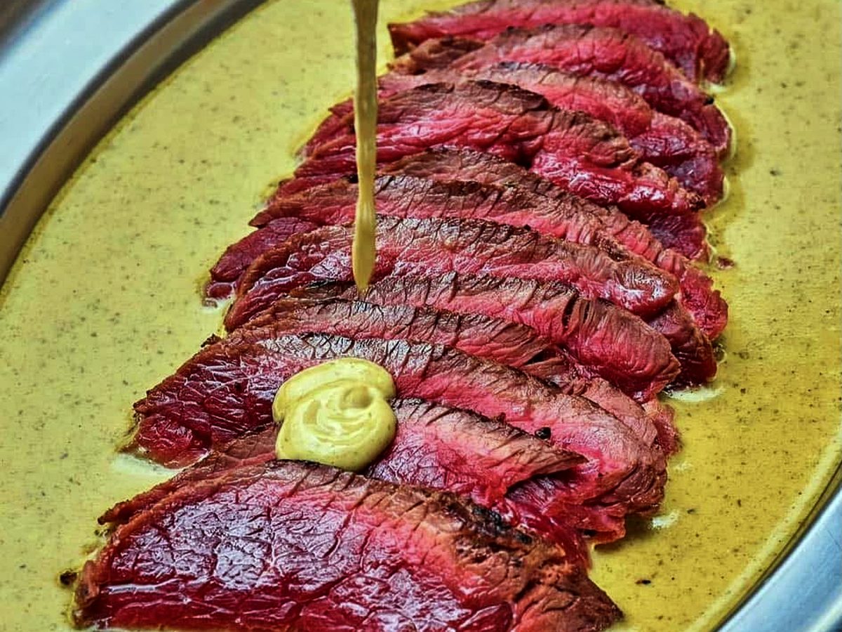Tranches de bœuf nappées de sauce dans un plat