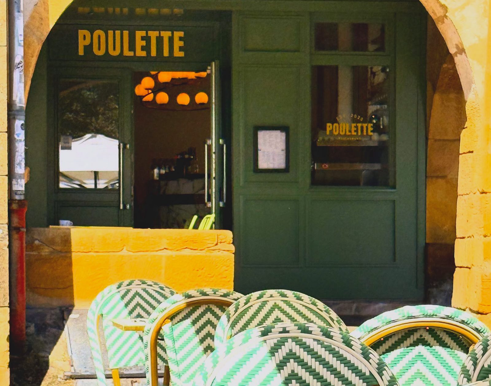 La devanture verte de Poulette sous les arcades de la place Saint-Louis