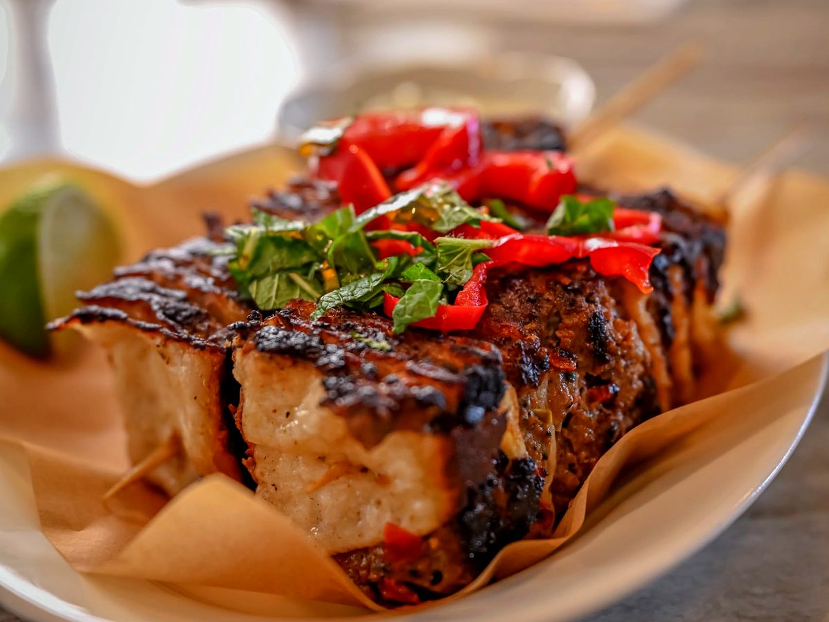 Brochettes grillées servies avec tomate, piment et herbes fraîches